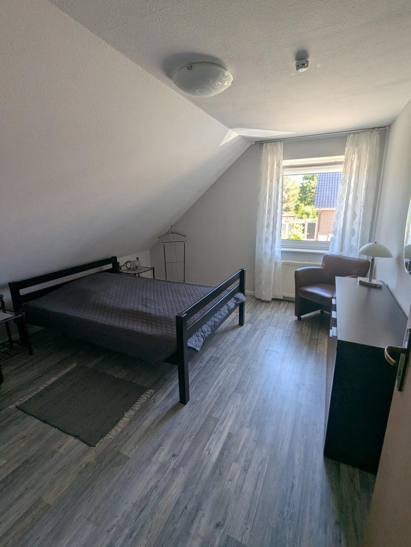 Schlafzimmer 2 mit Doppelbett, Sessel, Kommode und Fenster